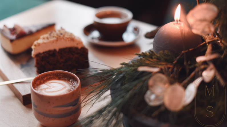 na zdjęciu świąteczny stroik, cappuccino z serduszkiem na piance i zapalona szara świeczka